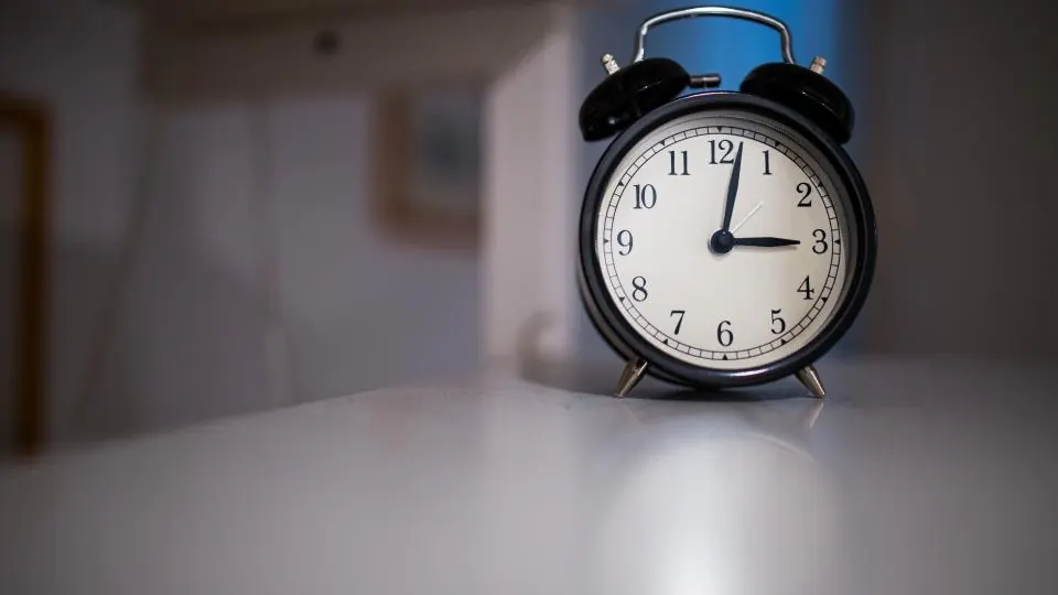 Black alarm clock on a white table