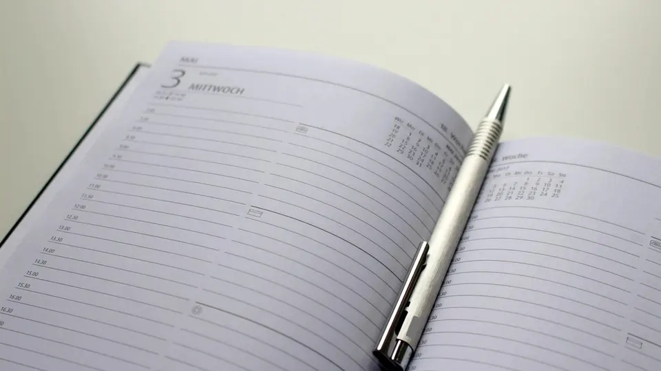 Open diary with a silver pen