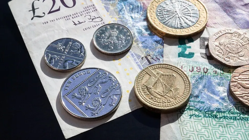 British pound coins on a £20 note