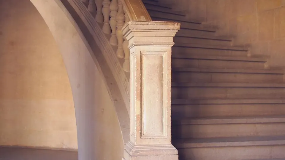Curved stone staircase with a carved balustrade